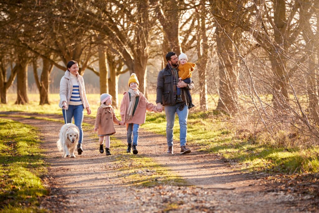 Pet dog with pet owner family walking in Autumn